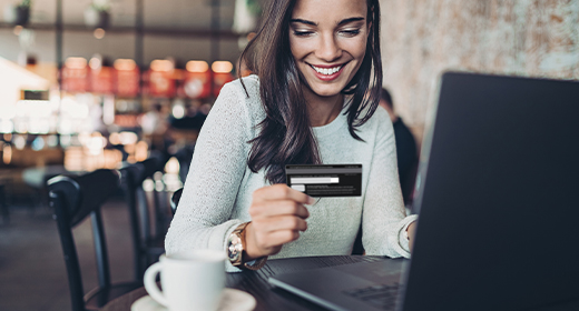 woman holding her credit card while on her laptop 520px 280px