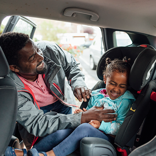 man putting his daughter into a carseat_540x540