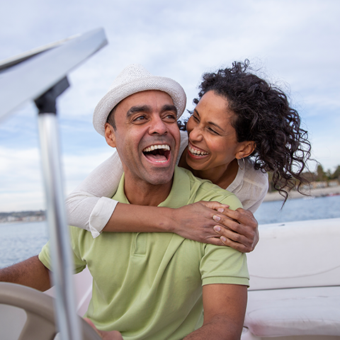 couple smiling and laughing while driving a boat 480x480