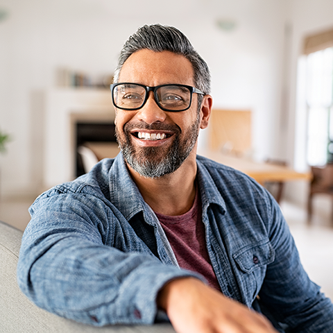 man with glasses sitting on couch and smiling 480x480_1