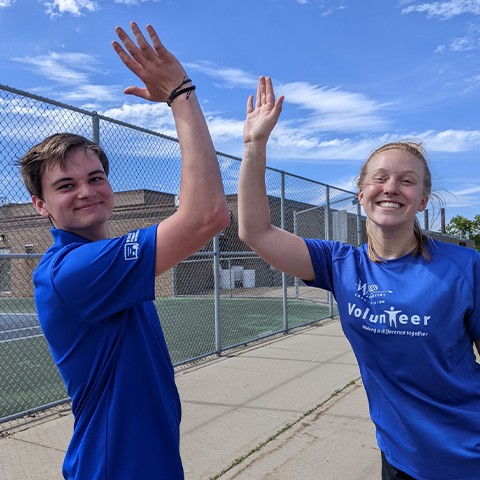 two wings interns high fiving after volunteering