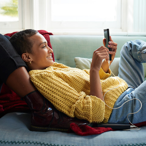 /getmedia/ca8be207 9abc 49ee bf19 95a4206bf4eb/Girl laying on a couch looking at her cell phone