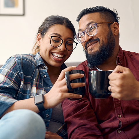 couple smiling having coffee together at home 480x480
