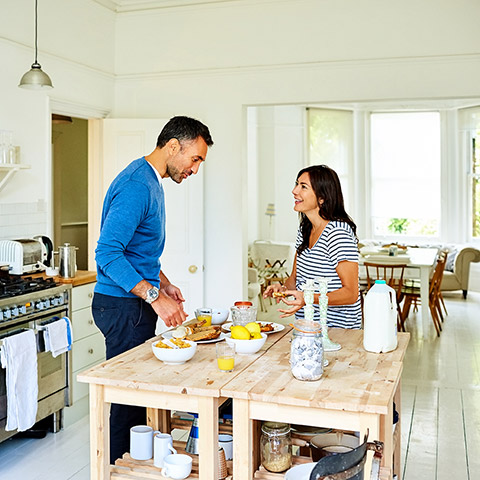Man and woman couple preparing food on their wood kitchen table